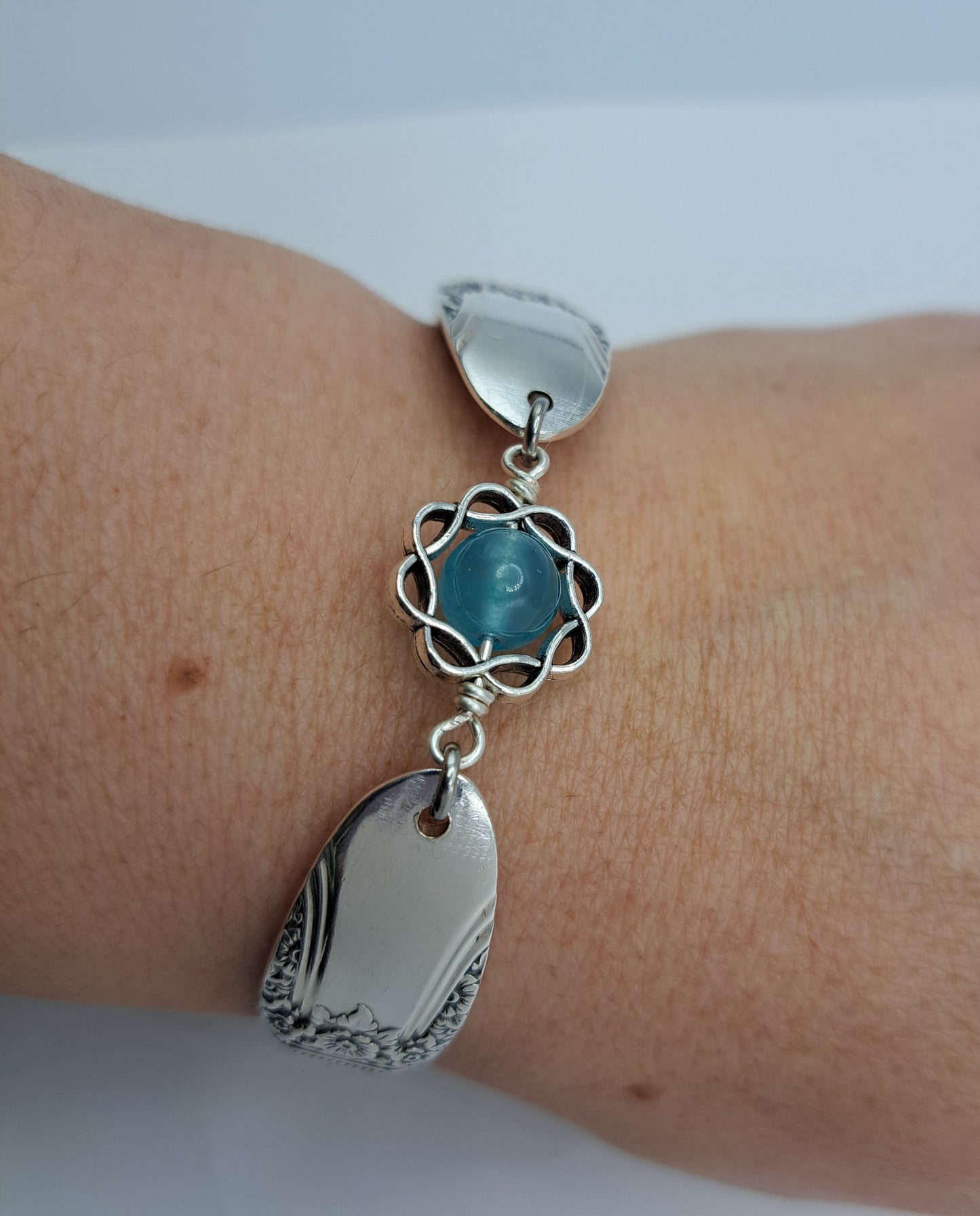 Handmade vintage silverware bracelet made from First Love 1937 pattern silverplated handles with blue bead center