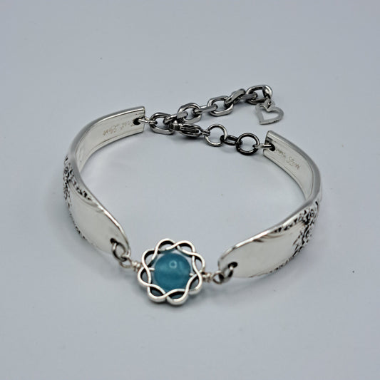 Handmade vintage silverware bracelet made from First Love 1937 pattern silverplated handles with blue bead center