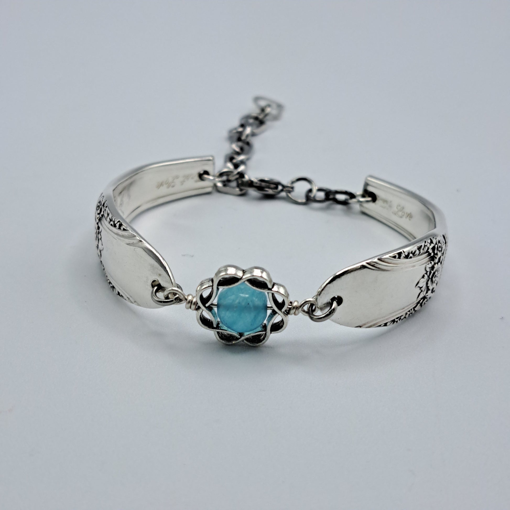 Handmade vintage silverware bracelet made from First Love 1937 pattern silverplated handles with blue bead center