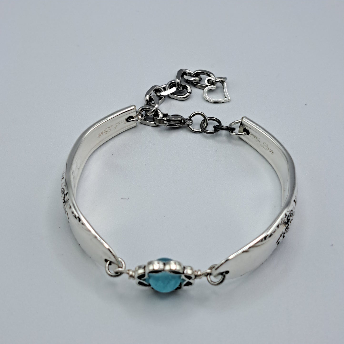 Handmade vintage silverware bracelet made from First Love 1937 pattern silverplated handles with blue bead center
