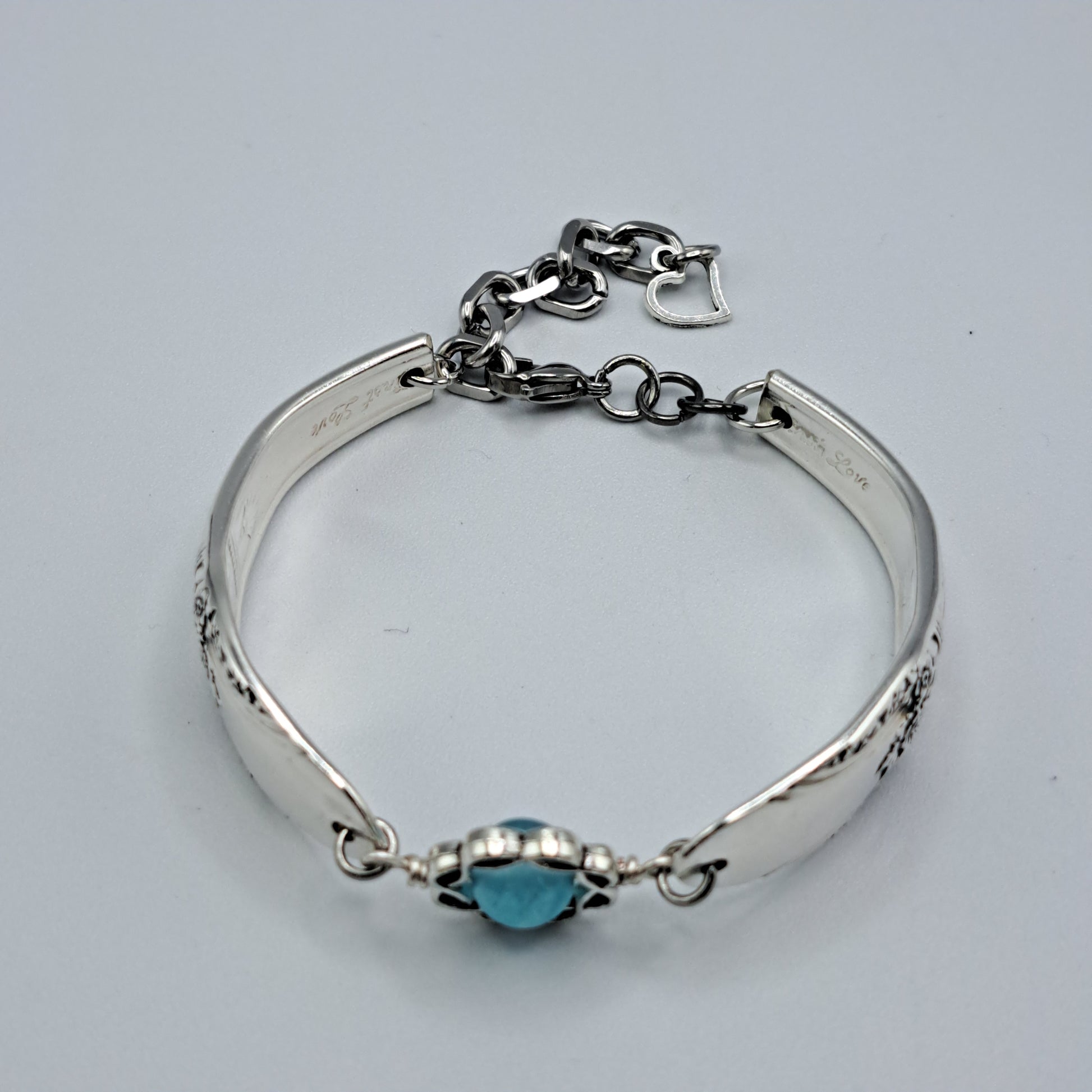 Handmade vintage silverware bracelet made from First Love 1937 pattern silverplated handles with blue bead center