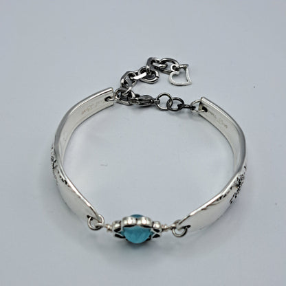 Handmade vintage silverware bracelet made from First Love 1937 pattern silverplated handles with blue bead center
